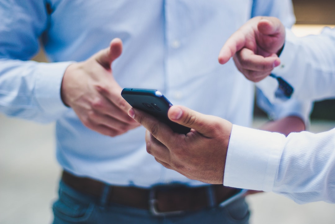 hands holding mobile phone and pointing